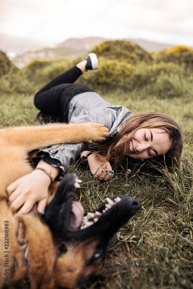 Young woman petting dog in nature Young woman petting dog in nature