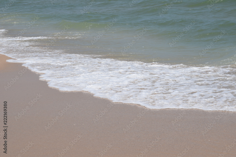 Diagonal close up of wet sand and soft wave use for summer background with place for text