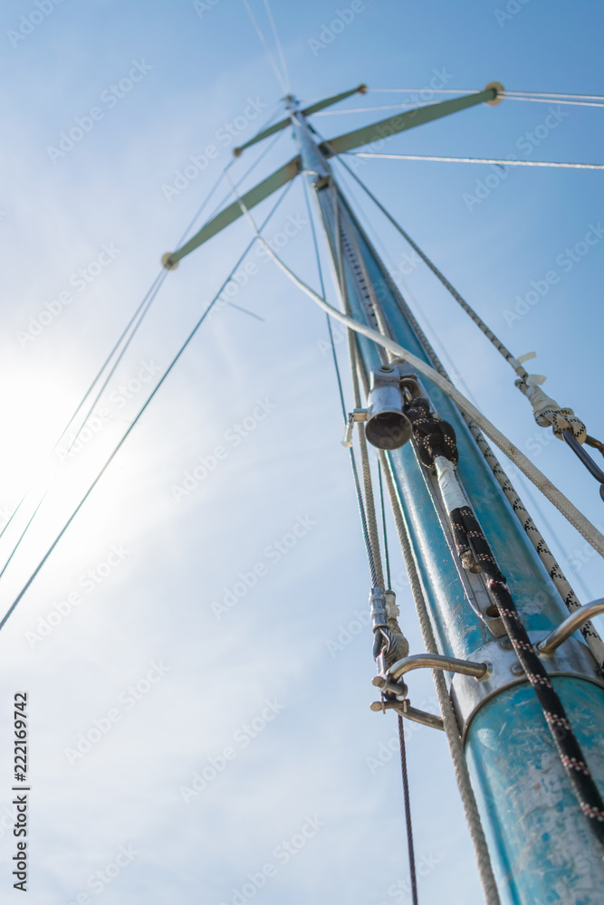 White sail of a sailing boat against sky. Sails of river sailing yacht in the wind against the blue sky White sail of a sailing boat against sky. Sails of river sailing yacht in the wind against the blue sky