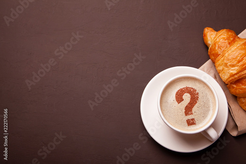 Cup of coffee with question mark  on foam. coffee break. FAQ