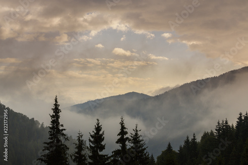 Summer mountain scenery with mist clouds  at sunset
