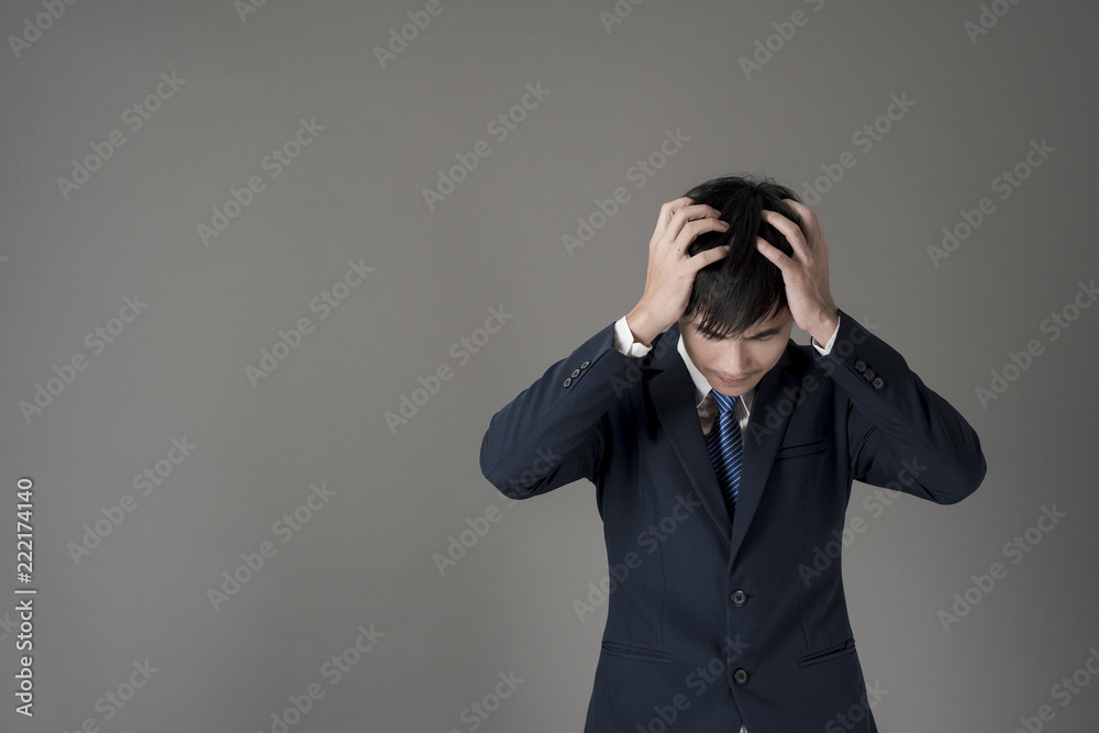 Business man is headache ,grey background in studio Business man is headache ,grey background in studio