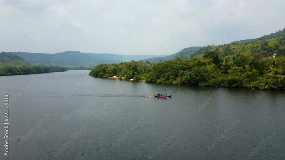 Cambodian long tail boat floats on the Preat river with tourists. Cambodia, Asia. Cambodian long tail boat floats on the Preat river with tourists. Cambodia, Asia.