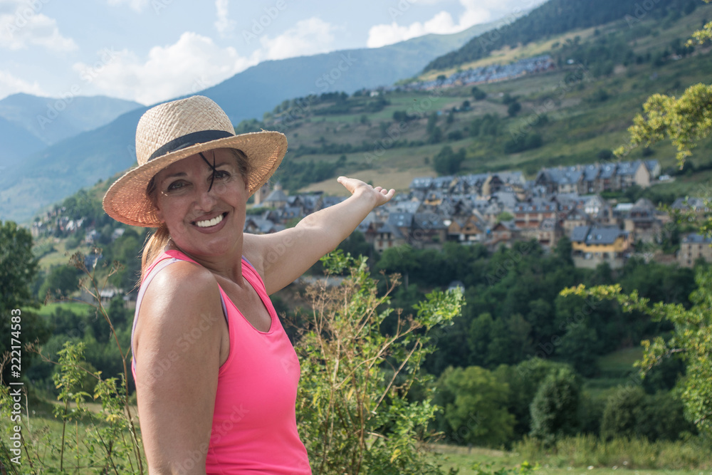 Woman hiking with a straw hat and backpack through the Spanish Pyrenees