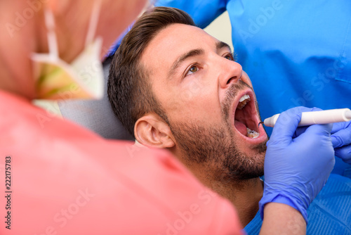 A handsome male patient waiting to receive a dental treatment in a dental studio photo