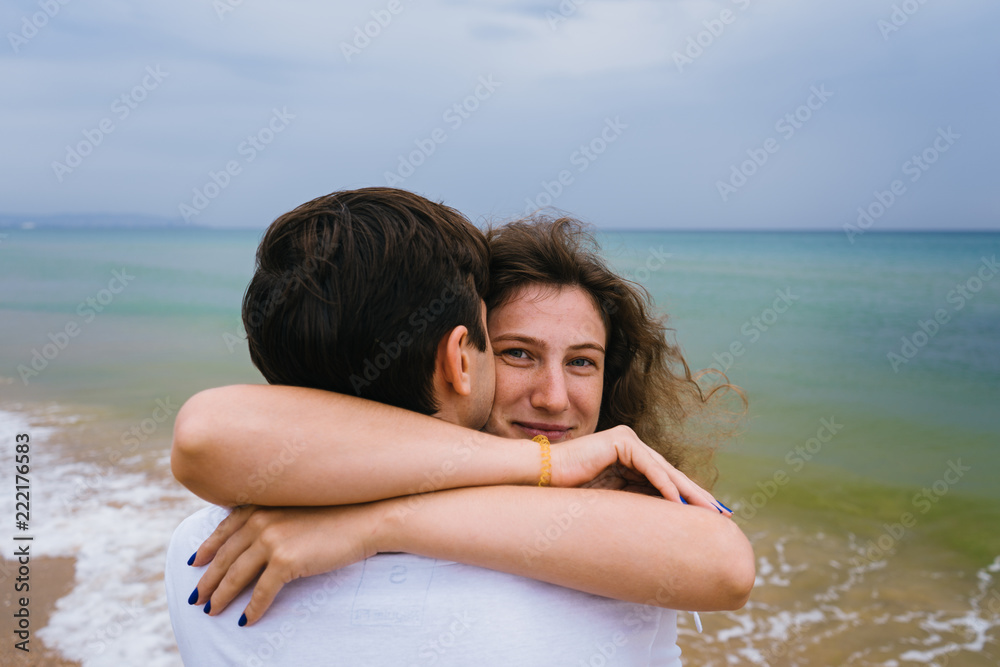 Happy couple strolling along the beach or ocean. Love couple walking along the coast.