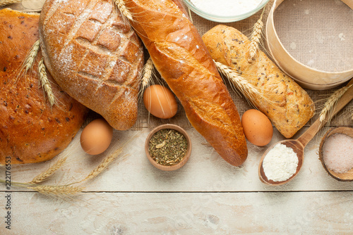 Bread of different varieties on a wood background with copy space background. The concept of bakery, cooking and grocery store. photo