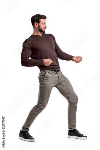 Photos A bearded man a jumper and pants tries to pull a strong invisible rope on a white background