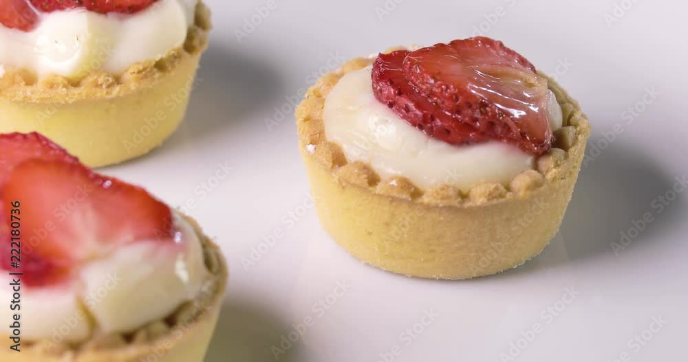 Pasticcini alla fragola e crema pasticciera su un piatto rotante bianco da esposizione Pasticcini alla fragola e crema pasticciera su un piatto rotante bianco da esposizione