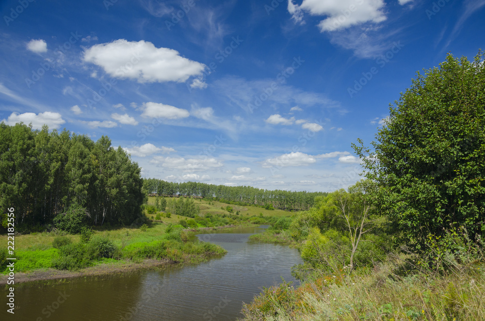 Sunny summer landscape with river,green hills and beautiful clouds in blue sky.Tula region,Russia.