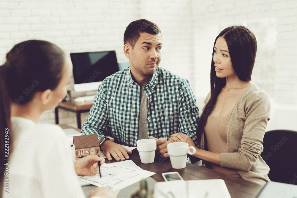 Fototapeta premium Young Man and Woman with Smiling Realtor in Office