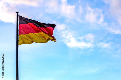 eine Deutschlandfahne vor blauem Himmel