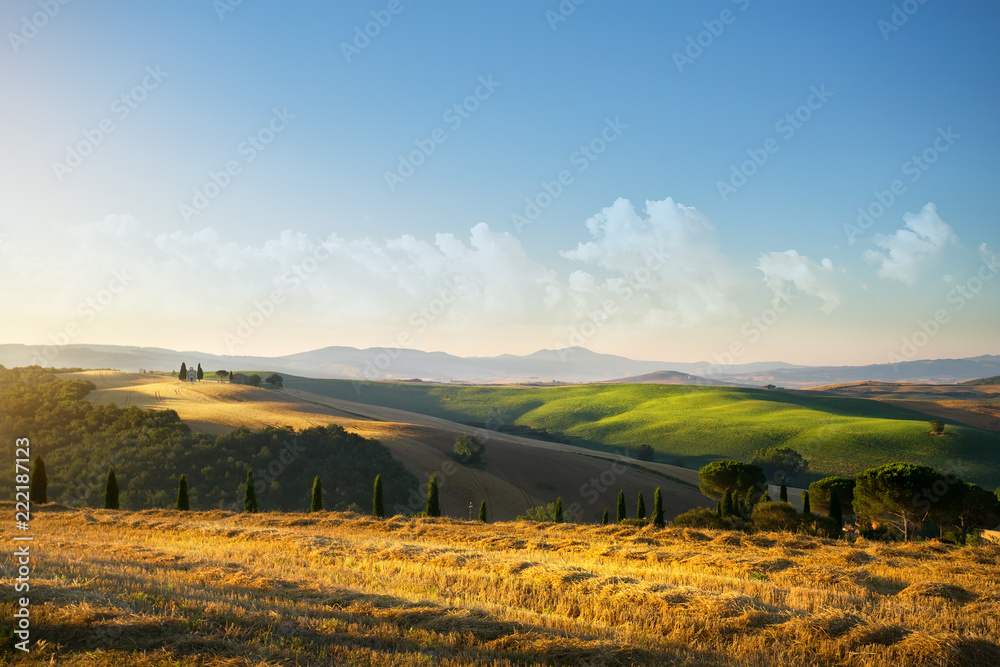 typical Tuscany countryside landscape; sunset over rolling hills and Tuscany village