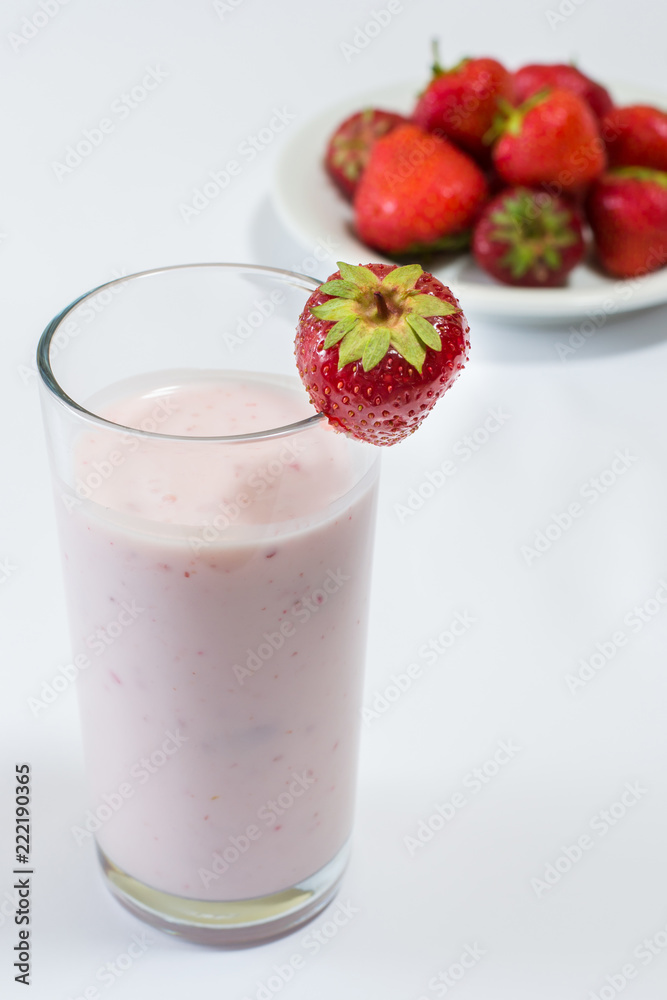 Glass of strawberry flavoured yogurt with fresh strawberries on plate. Concept of healthy nutrition Glass of strawberry flavoured yogurt with fresh strawberries on plate. Concept of healthy nutrition