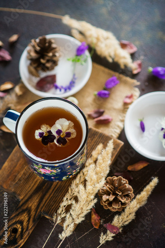 Photos Flower tea: pansies, edible flowers, on a light background