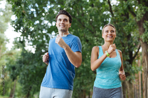 Healthy hobby. Delighted sportive couple smiling while enjoying sports activities together