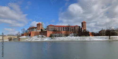 Obraz Zamek Królewski na Wawelu w Krakowie, widok z przeciwległego brzegu Wisły, zima, niewielki śnieg na nasypie, wspaniałe chmury w ruchu w błękitne niebo