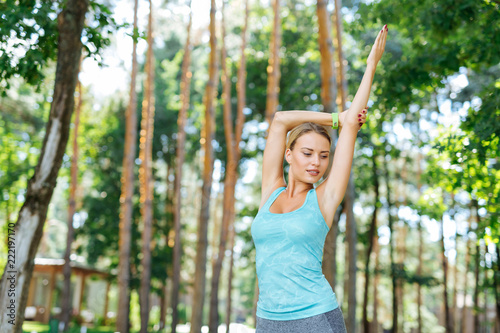 Peace of mind. Pleasant young woman standing in the special pose while practicing yoga outdoors
