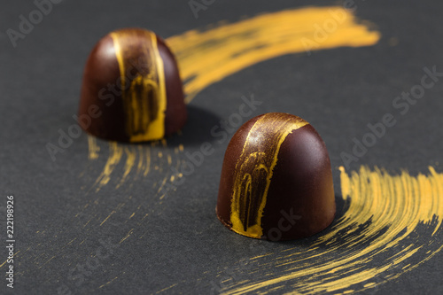Luxury bonbons painted with gold on black background