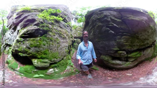 360 vr of mature man walking through a slot in large boulders. photo