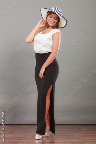 Woman wearing long black white dress and sun hat