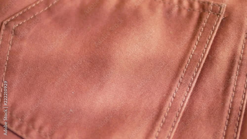 Orange fabric textile pants with pockets turns as background Orange fabric textile pants with pockets turns as background