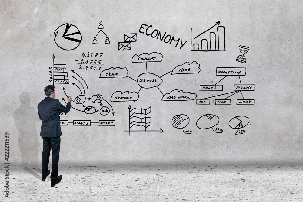 Businessman drawing his business ideas on a wall