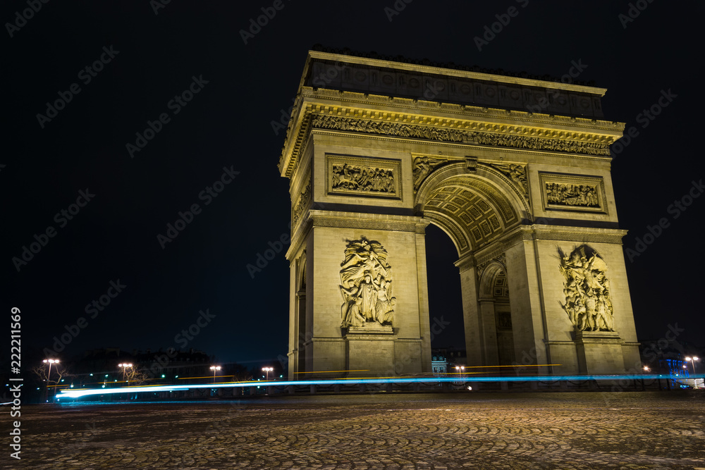 Street view of Arc de Triomphe (Triumphal Arch) in Chaps Elysees at night, Paris, France.