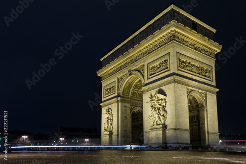 Street view of Arc de Triomphe (Triumphal Arch) in Chaps Elysees at night, Paris, France.