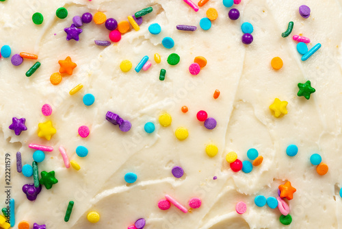 Close up of vanilla buttercream icing with colorful confetti sprinkles photo
