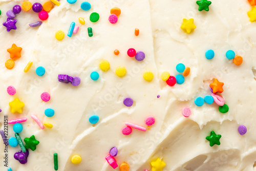 Fotografie Close up of vanilla buttercream icing with colorful confetti sprinkles