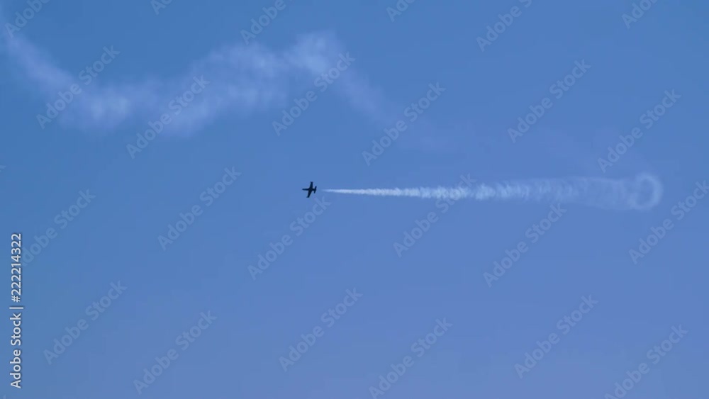 One airplane flying on the background of blue sky and leaving a condensation trail. 4K One airplane flying on the background of blue sky and leaving a condensation trail. 4K