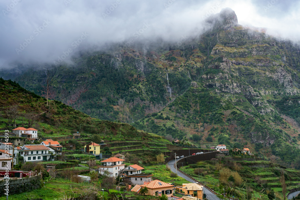 Village and beautiful mountains with clouds, in Madeira