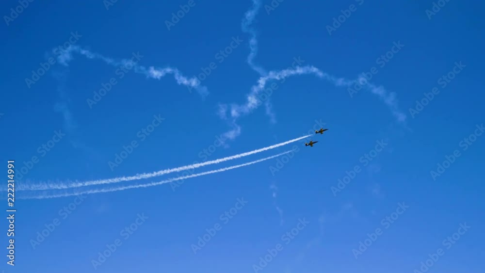 Two airplanes flying on the background of blue sky and leaving a condensation trail. 4K Two airplanes flying on the background of blue sky and leaving a condensation trail. 4K