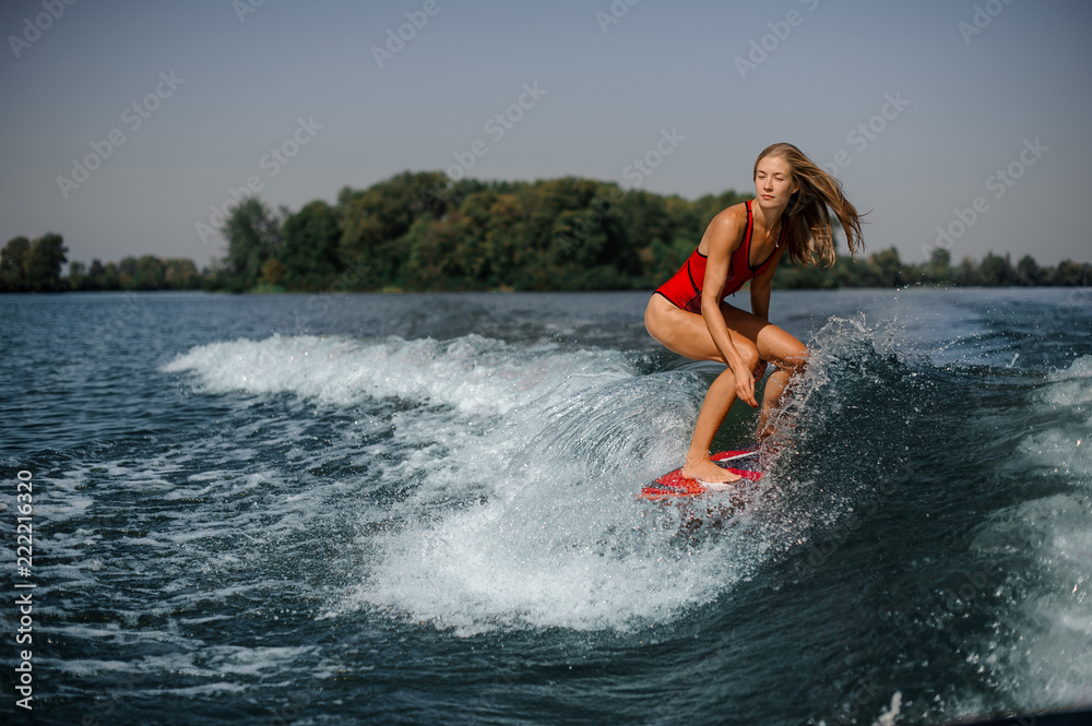 Blonde girl riding on the red wakeboard Blonde girl riding on the red wakeboard