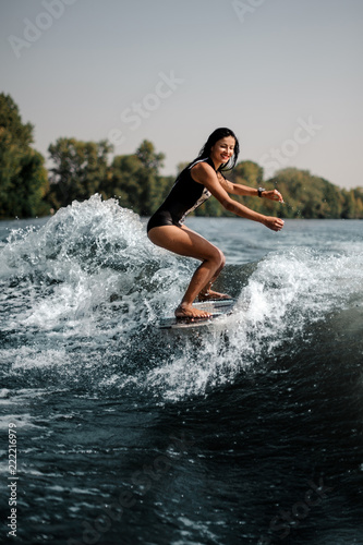 Brunette girl riding on the wakeboard on the bending knees © fesenko