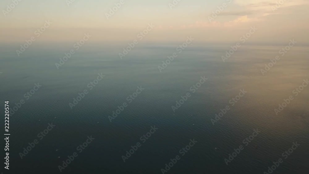 Aerial view: Sea water surface at sunset. Flying over the blue ocean with blue water, sky. Bali,Indonesia.4K video. Travel concept. Aerial footage