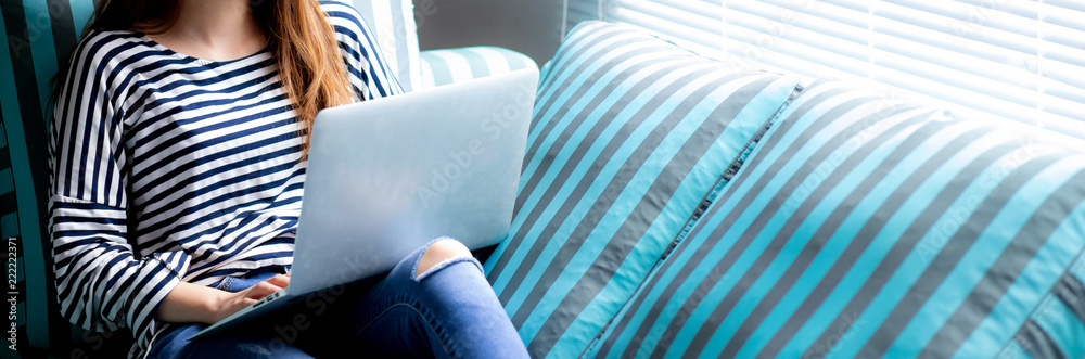Φωτογραφία Banner website beautiful of portrait young asian woman using laptop for leisure on sofa in living room, girl working online with notebook freelance with a happy, communication business concept