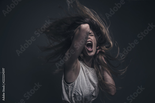 фотографія Crazy, deranged young woman screaming with frustration, expressing madness and r
