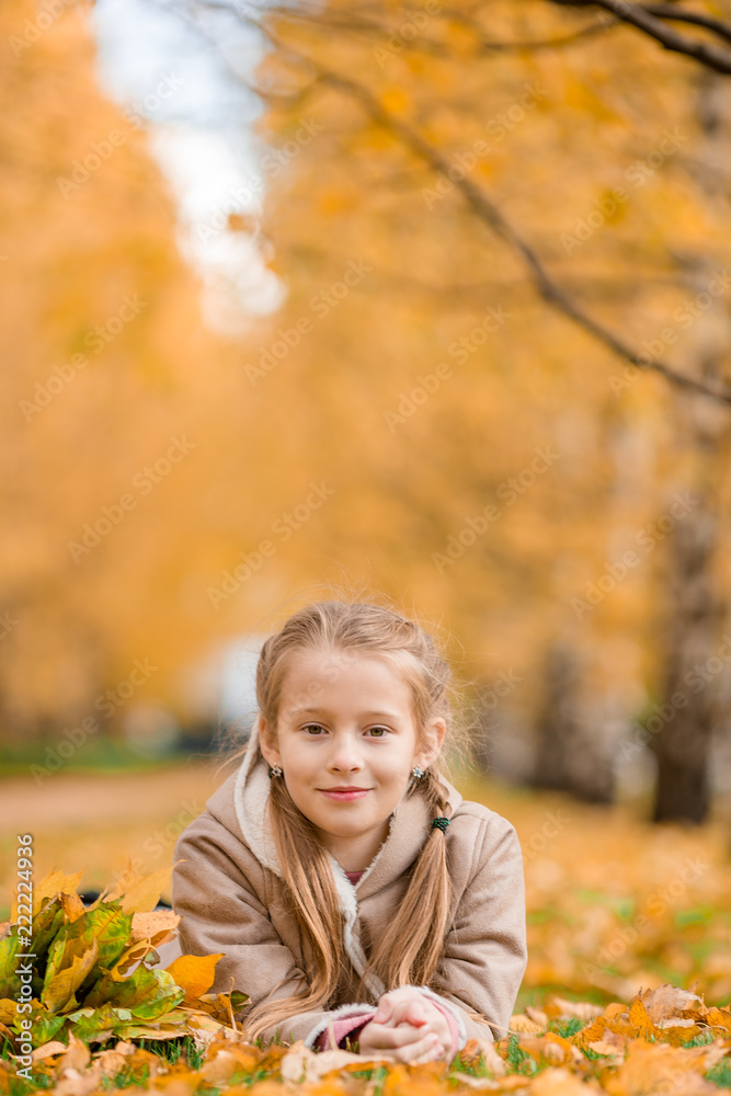 Portrait of adorable little girl outdoors at beautiful warm day with yellow leaf in fall Portrait of adorable little girl outdoors at beautiful warm day with yellow leaf in fall