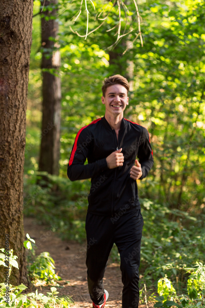 Young boy jogging through forest