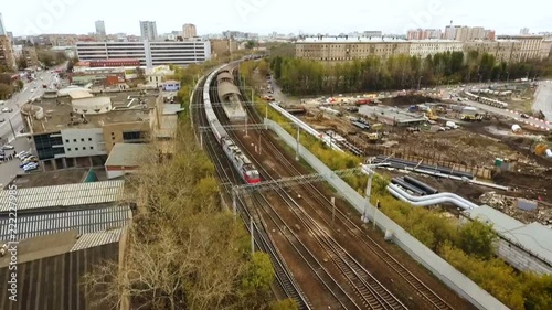 Quadcopter view Moscow city. On the railroad tracks a passenger train rides photo