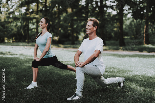 Young Couple in Sportswear Doing Exercises in Park