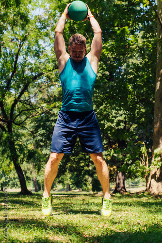 Fitness Trainer doing workout in nature with the kettle bell