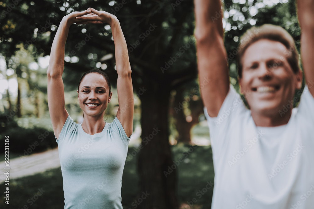 Young Couple in Sportswear Doing Exercises in Park