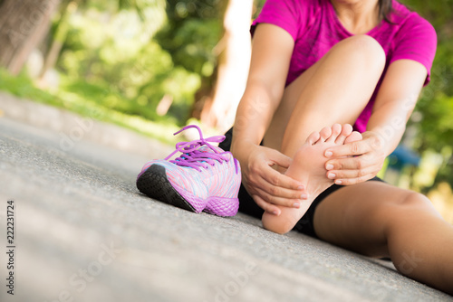 Young woman massaging her painful foot from exercising and running Sport and excercise concept.