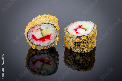 Hot roll with tempura crab on black with reflection
