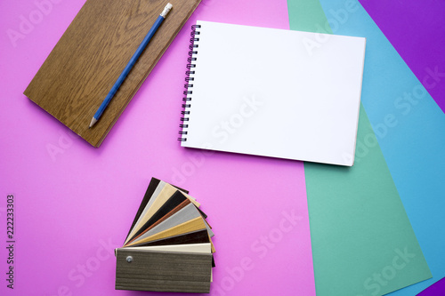 white notebooks with pencil and sample material. Placed on a colorful background.