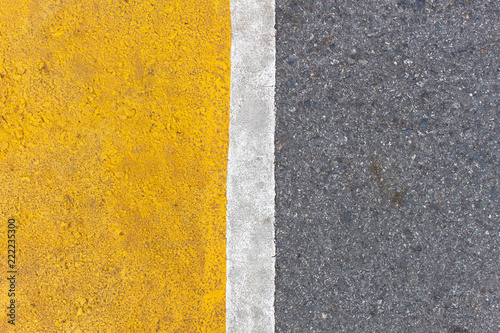 Background of yellow black strips . Dark grey asphalt road divided by yellow paint. yellow black background