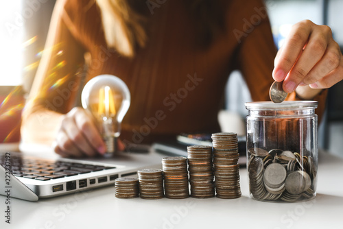 businesswoman holding coins putting in glass with using smartphone and calculator to calculate concept saving money for finance accounting